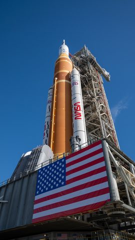 Artemis II SLS rolls out beside the flag by NASA — large framed print